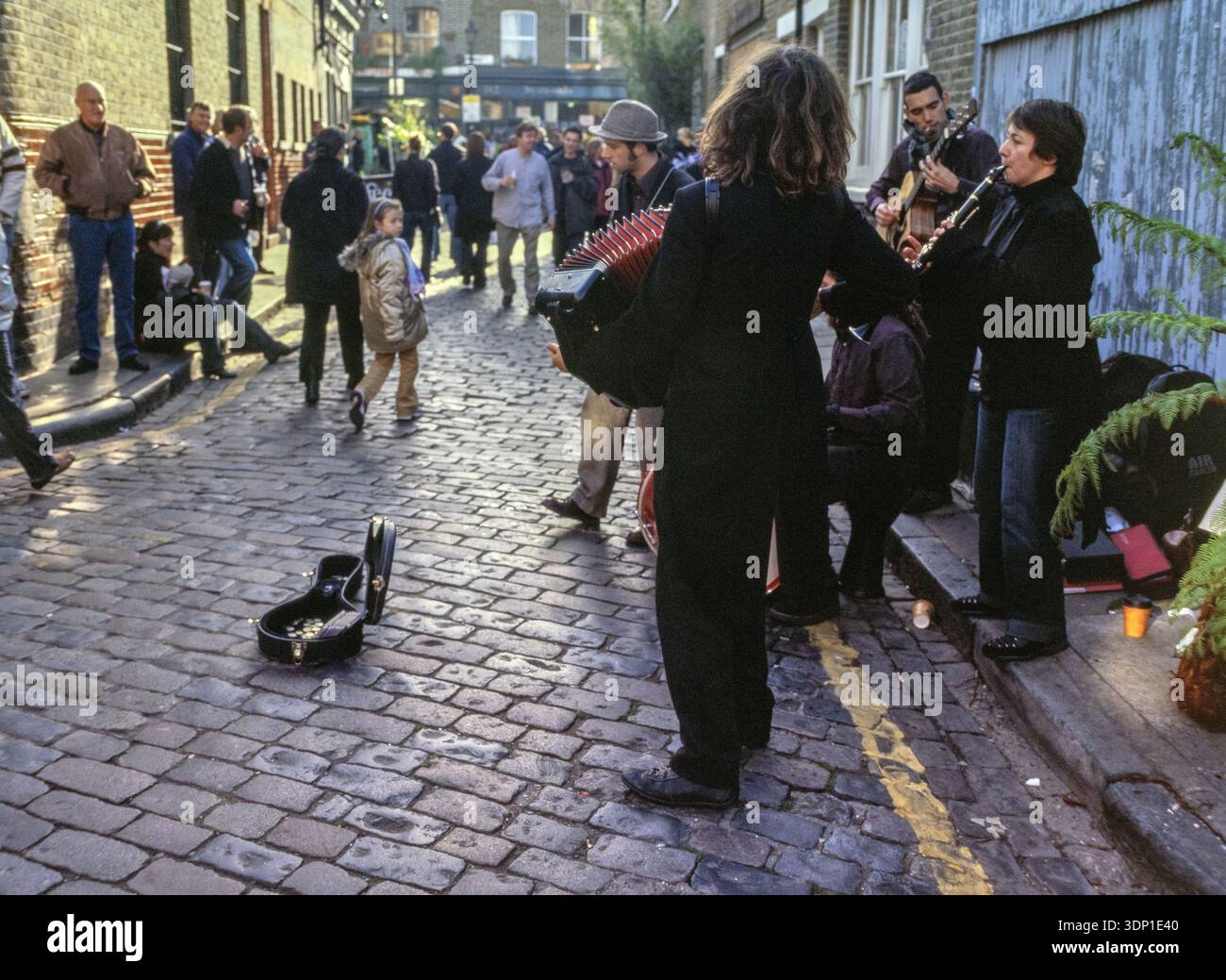 Vista sulla strada del Columbia Flower Market a Londra, Regno Unito, con spettacoli di busker e acquirenti Foto Stock