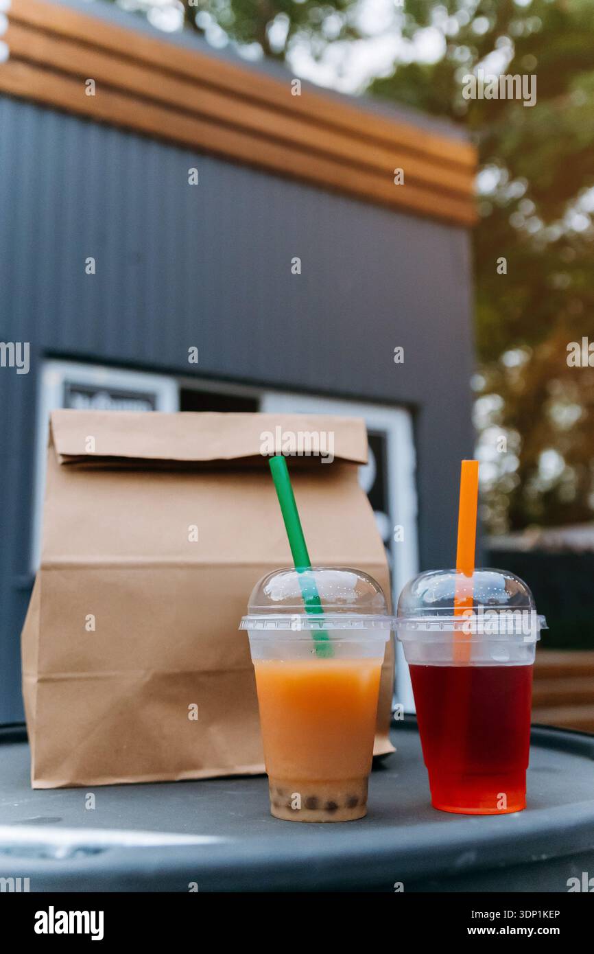 Bollicine da asporto e bevanda alla frutta con sacchetto di carta all'esterno del food truck Foto Stock
