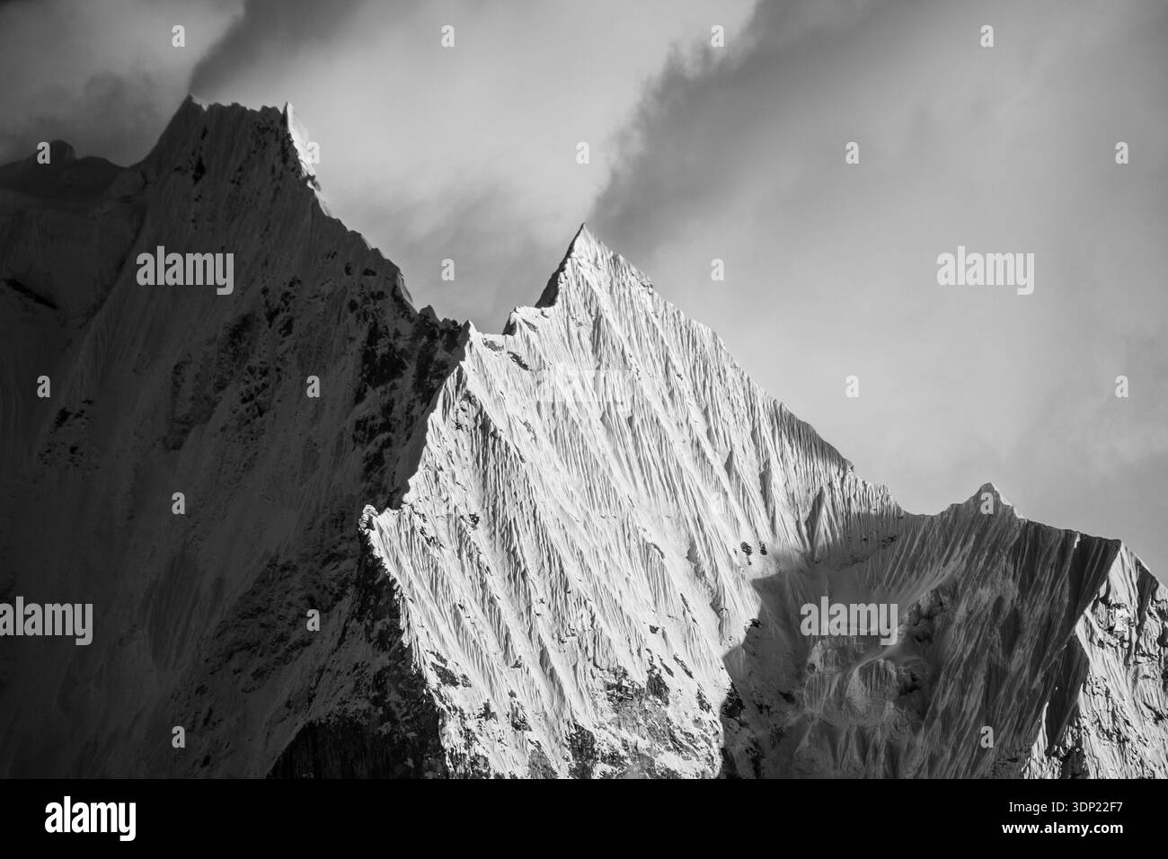 Il picco di Thamserku si illumina di una splendida luce dorata del tramonto, sopra la regione di Khumbu in Nepal. Il caldo alpenglow illumina la neve e il ghiaccio di questo... Foto Stock