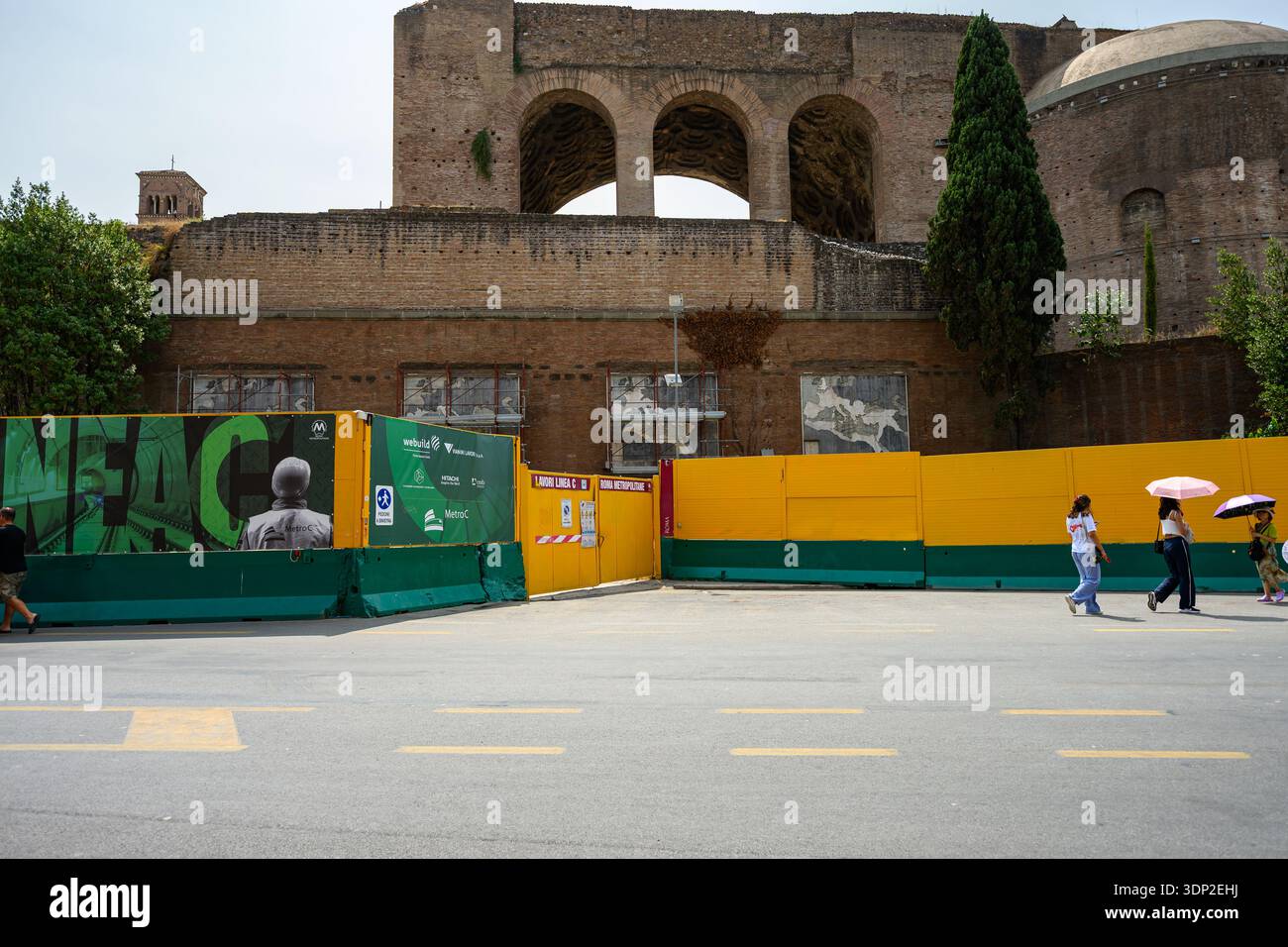 Roma, Italia. 19 agosto 2024: Il movimento pedonale continua lungo i lavori di costruzione della linea C della metropolitana nei pressi del quartiere archeologico del Colosseo. Foto Stock