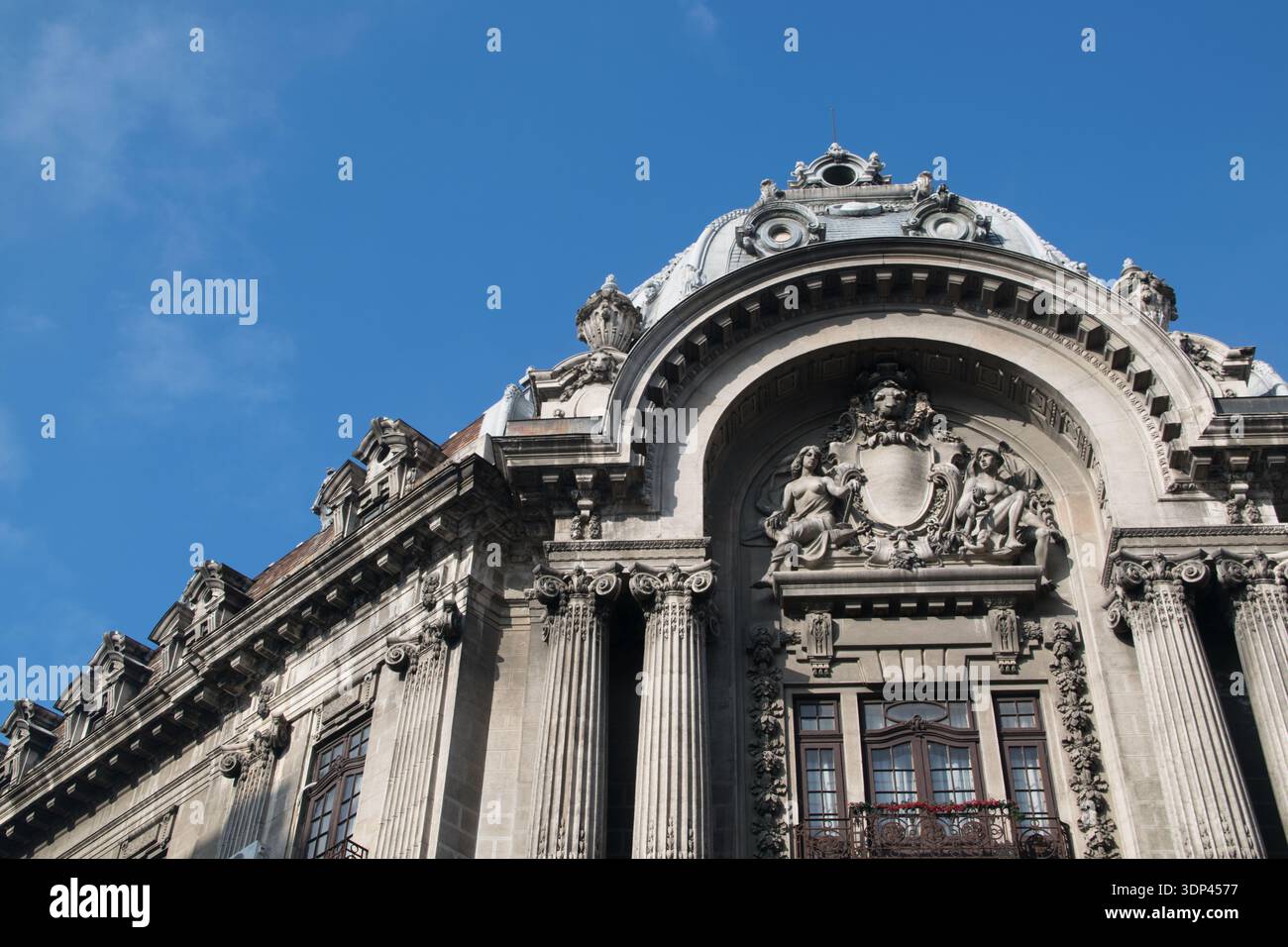 I visitatori ammirano gli intricati dettagli di un vecchio edificio nella città vecchia di Bucarest durante una giornata di sole con un cielo azzurro. Foto Stock