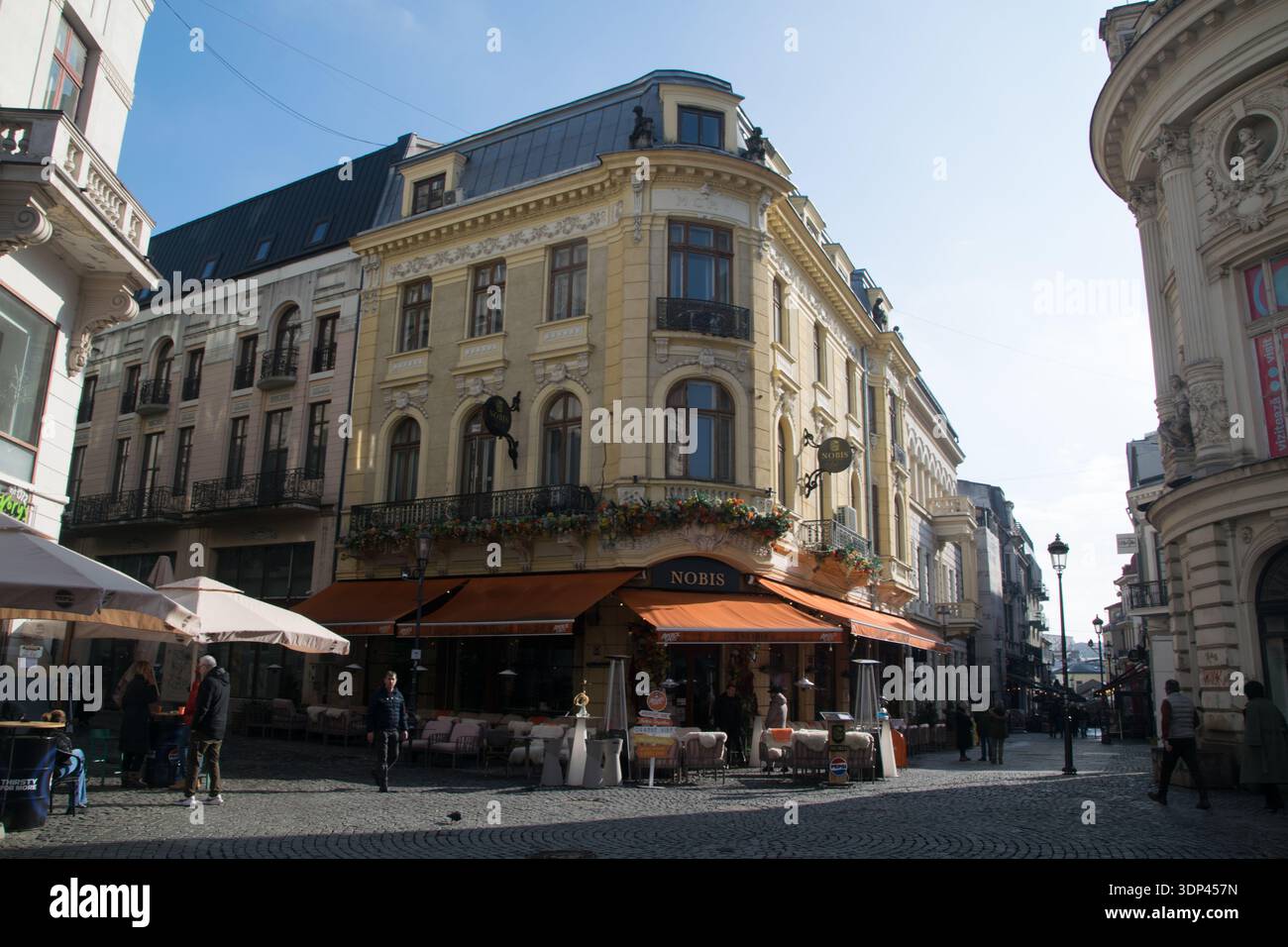 I visitatori camminano lungo le strade acciottolate della città vecchia di Bucarest, ammirando l'architettura e gustando una cena all'aperto nei caffè vicini. Foto Stock