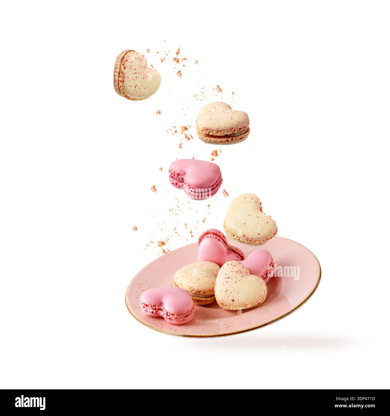 Biscotti francesi a forma di cuore, macaron, macaron con briciole che cadono su un piatto rosa vintage isolato su sfondo bianco. Pasticceria Foto Stock