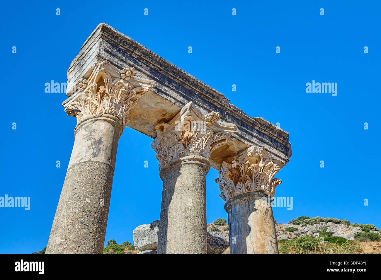 Le colonne corinzie ornate si stagliano da sole presso l'antica città in rovina di Efeso, Turchia, Europa, Asia occidentale Foto Stock