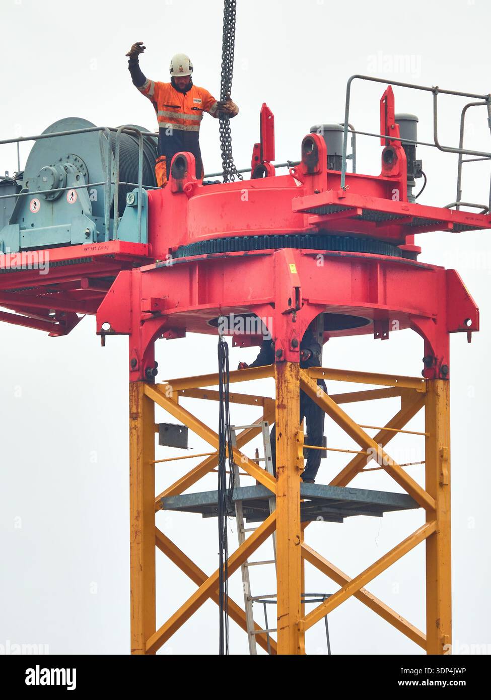 Operaio edile su gru a torre che indossa l'attrezzatura di sicurezza in quota sul sito industriale Foto Stock