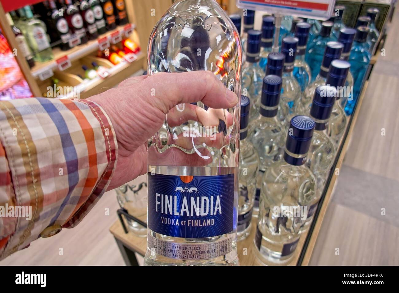 Helsinki, Finlandia, Europa - 22 maggio 2025: Bottiglia di vodka Finlandia tenuta a mano da uomo nell'area commerciale duty-free del traghetto Viking Line, M/S Viking XPRS. Foto Stock