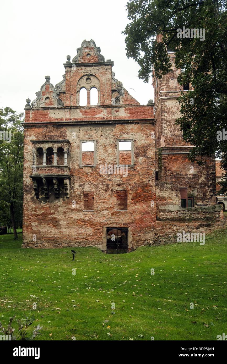 Storico Ruin Showcase. Architettura in pietra antica e mattoni con finestre rotte e dintorni ricoperti di vegetazione Foto Stock