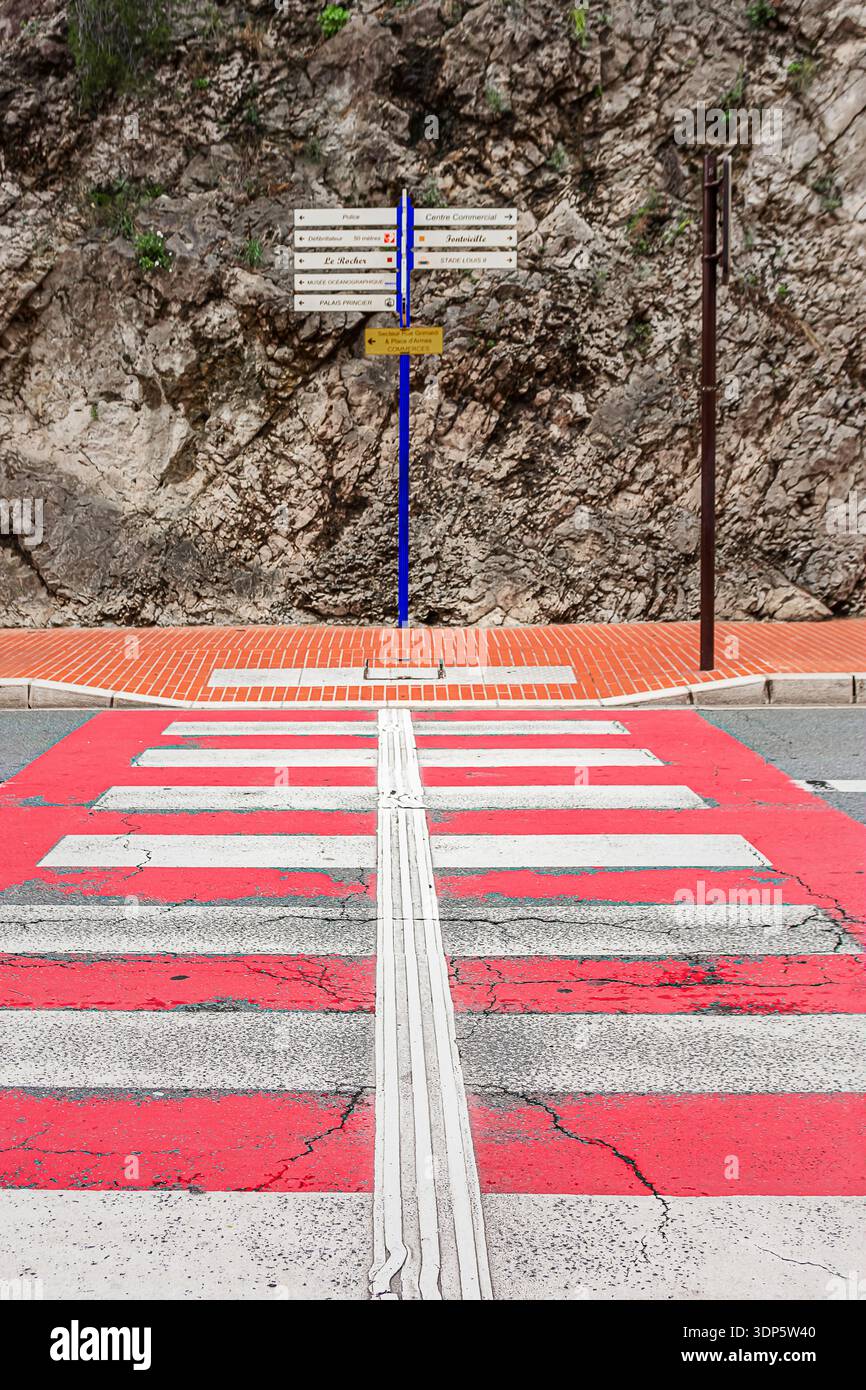 Un passaggio pedonale con linee rosse e bianche e cartelli stradali a Monte Carlo Foto Stock