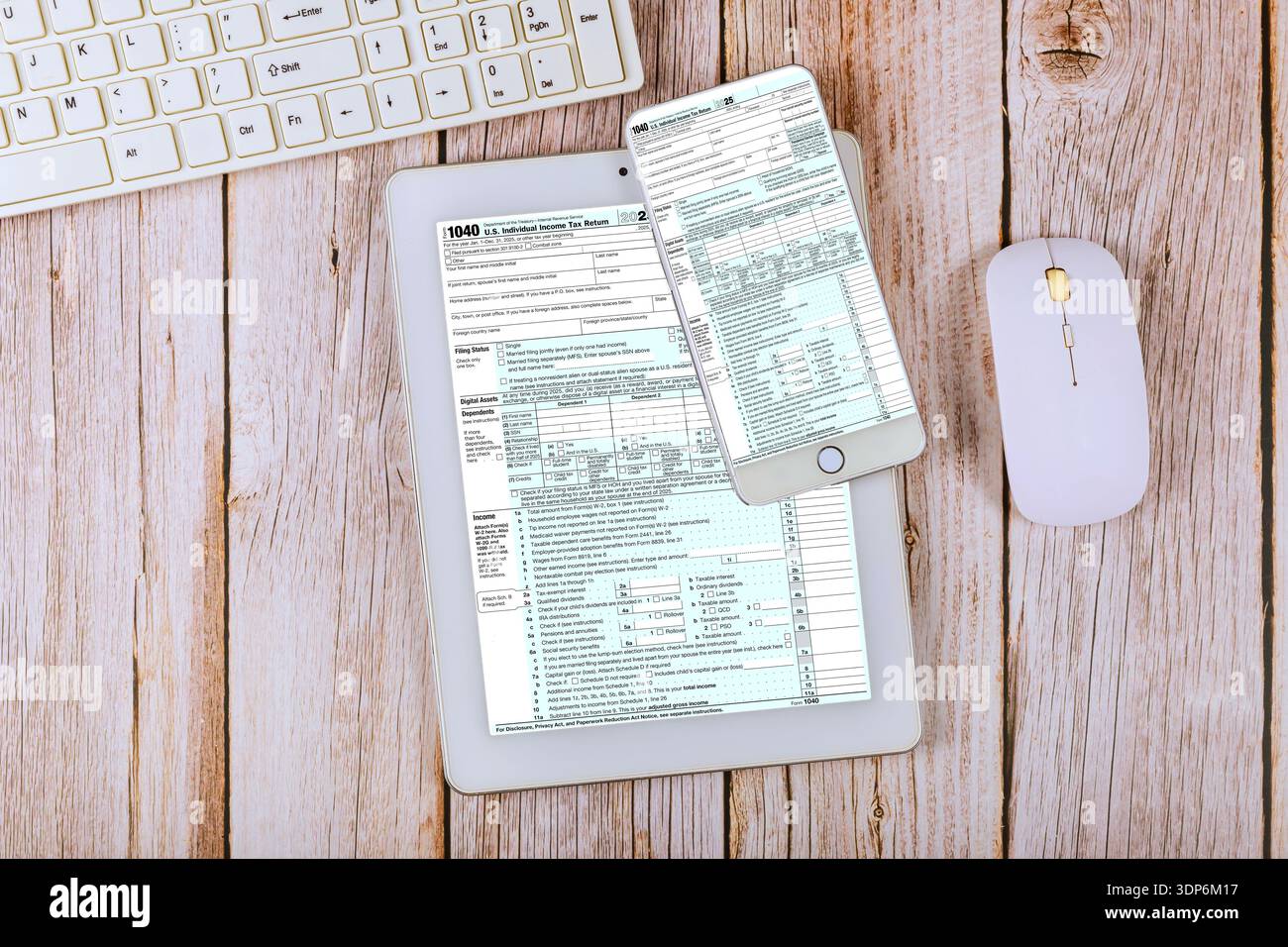 I moduli Tax 1040 vengono aperti su tablet digitale, smartphone sulla scrivania dell'ufficio contabilità con tastiera del computer e mouse nelle vicinanze Foto Stock
