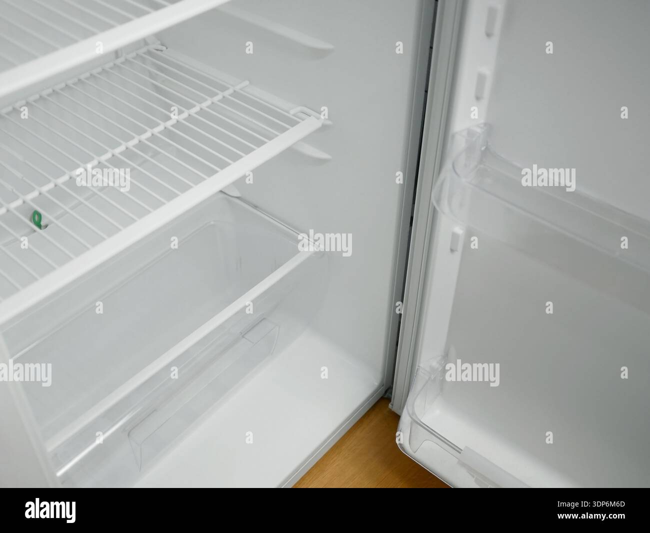 Frigorifero aperto vuoto con ripiani a griglia e sportelli trasparenti. Interno del frigorifero bianco pulito, moderno elettrodomestico da cucina, concetto di cella frigorifera con Foto Stock