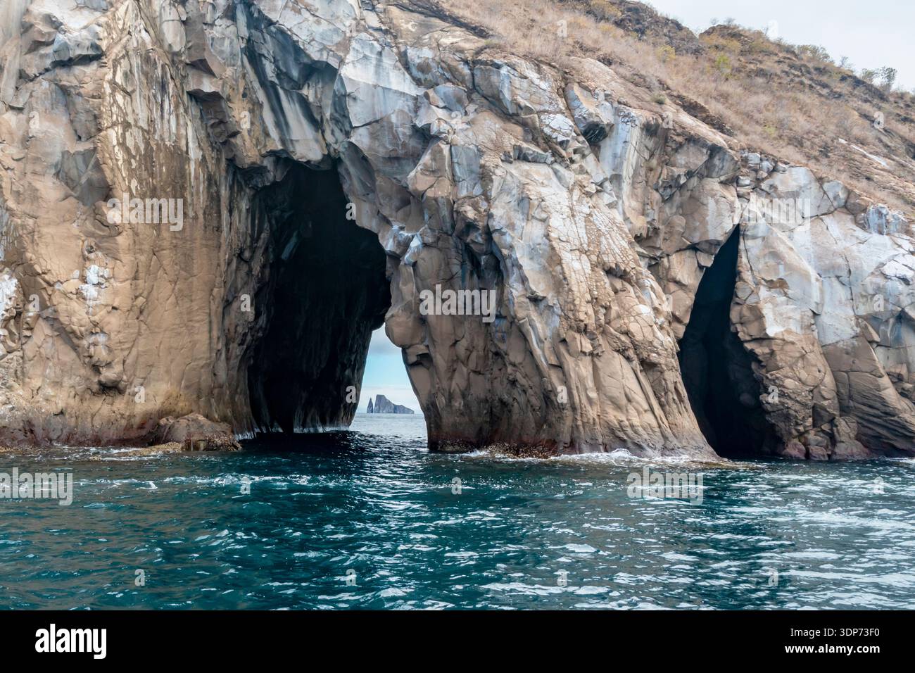 Arco de Cerro Brujo (Isla Cristobal, Galapagos): Formazioni rocciose naturali nell'acqua. Sullo sfondo, Kicker Rock viene osservato attraverso una grotta. Foto Stock