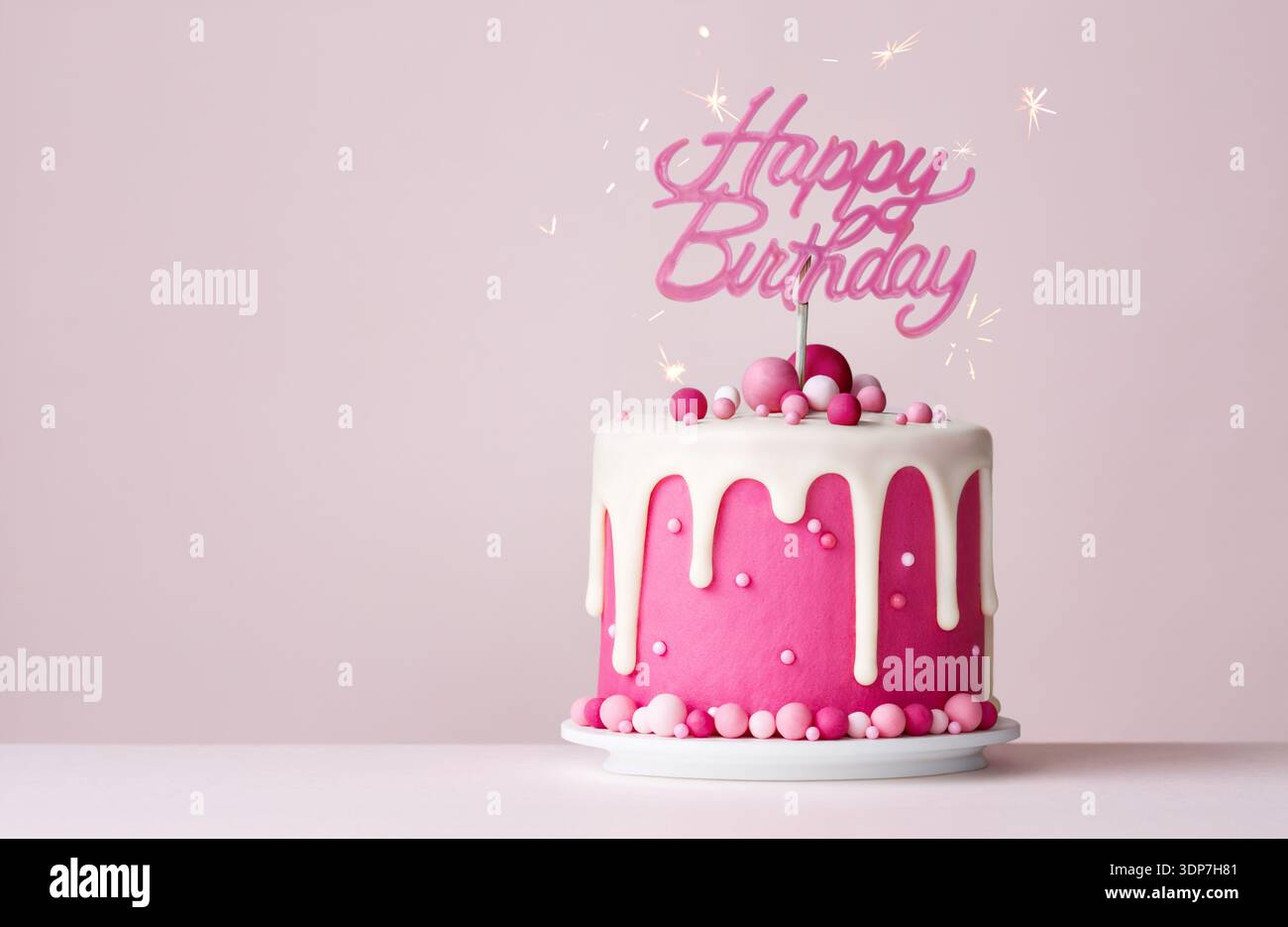 Torta di compleanno rosa per festeggiamenti con glassa a goccia e striscione rosa per buon compleanno Foto Stock