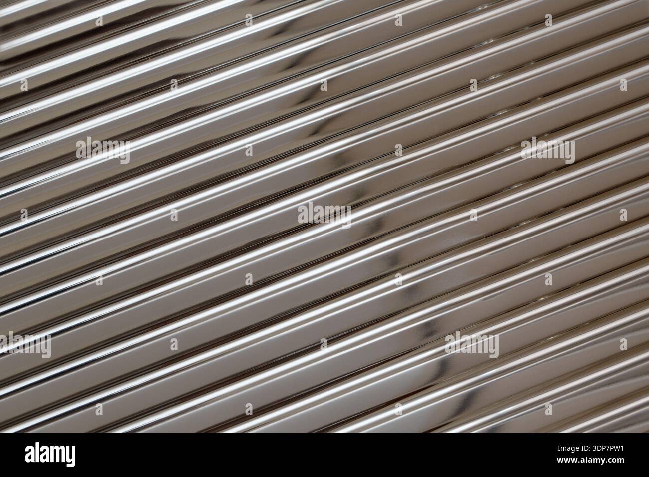 Superficie cromata lucida che mostra linee parallele e una trama strutturata Foto Stock