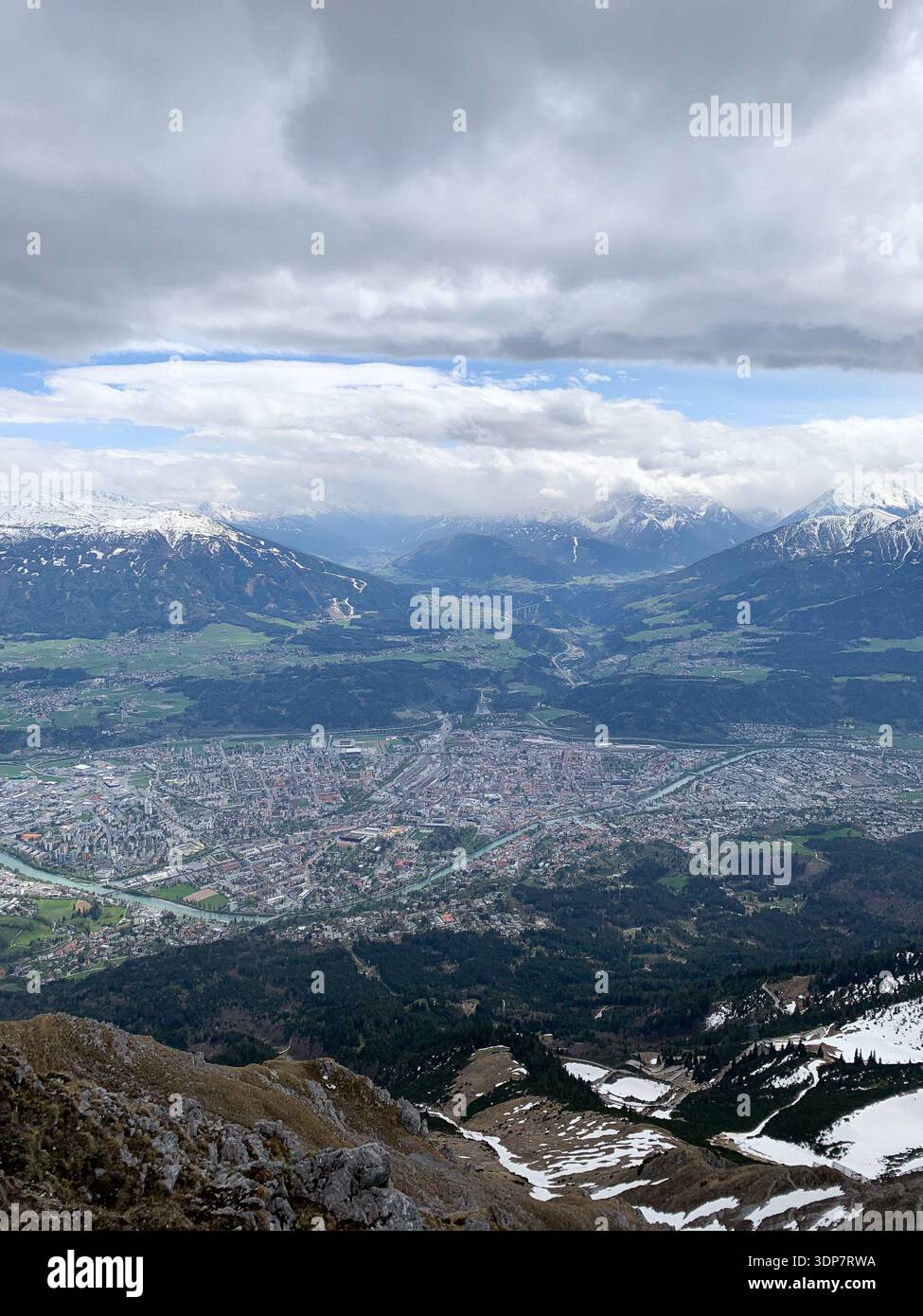 Vista su Innsbruck e sul fiume Inn dalle montagne ad aprile. Vista panoramica dalla cima della Nordkette a Innsbruck e alla catena montuosa, Tirol, Austria. - Immagine stock catturata con smartphone