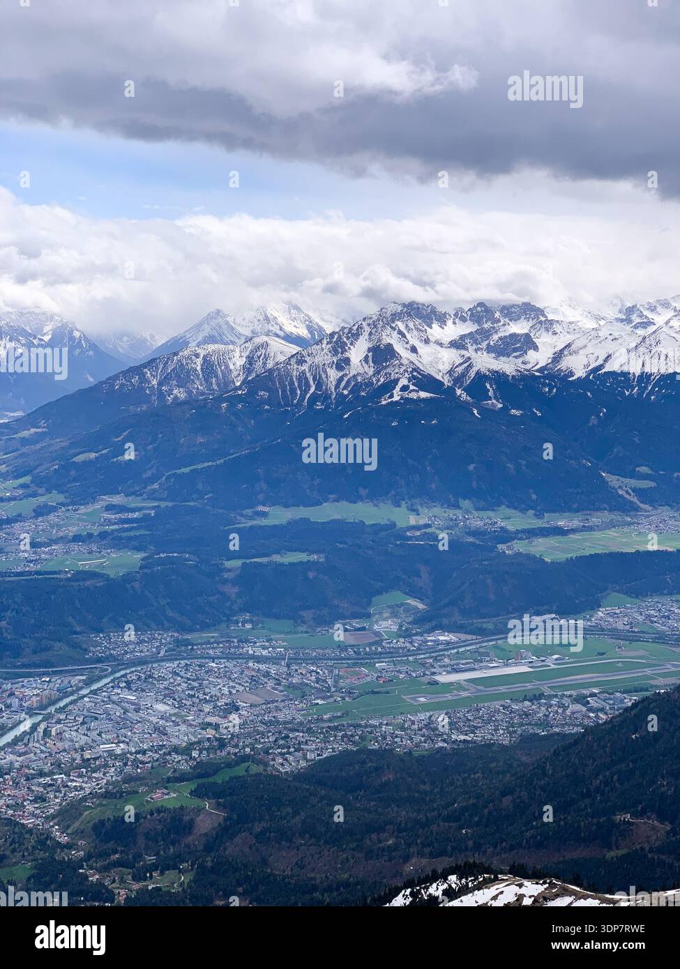 Vista su Innsbruck e sul fiume Inn dalle montagne ad aprile. Vista panoramica dalla cima della Nordkette a Innsbruck e alla catena montuosa, Tirol, Austria. - Immagine stock catturata con smartphone