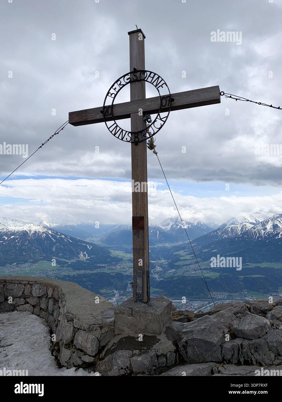 La croce in cima a Innsbruck. Bergsöhne. Vista su Innsbruck e sul fiume Inn dalle montagne ad aprile. Vista panoramica dalla cima della Nordkette all'Inn - Immagine stock catturata con smartphone