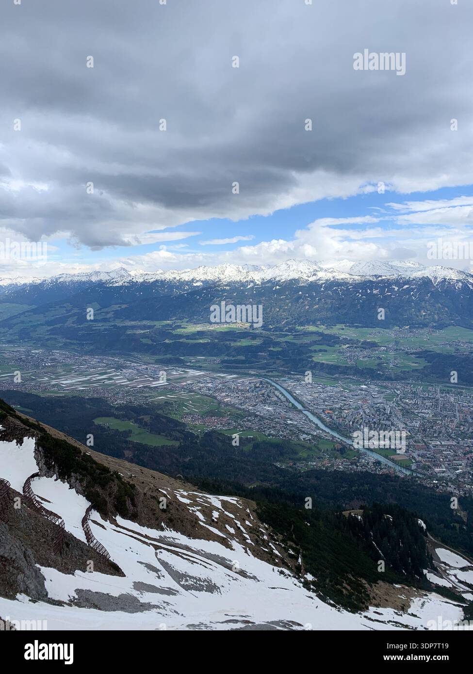 Vista su Innsbruck e sul fiume Inn dalle montagne ad aprile. Vista panoramica dalla cima della Nordkette a Innsbruck e alla catena montuosa, Tirol, Austria. - Immagine stock catturata con smartphone