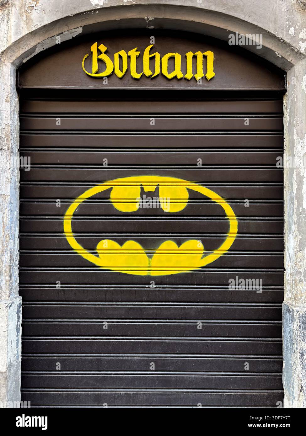Vernice spray con logo Batman su serranda di sicurezza chiusa "Botham", Catania, Sicilia. Riferimento alla Street art di Gotham City. Foto Stock