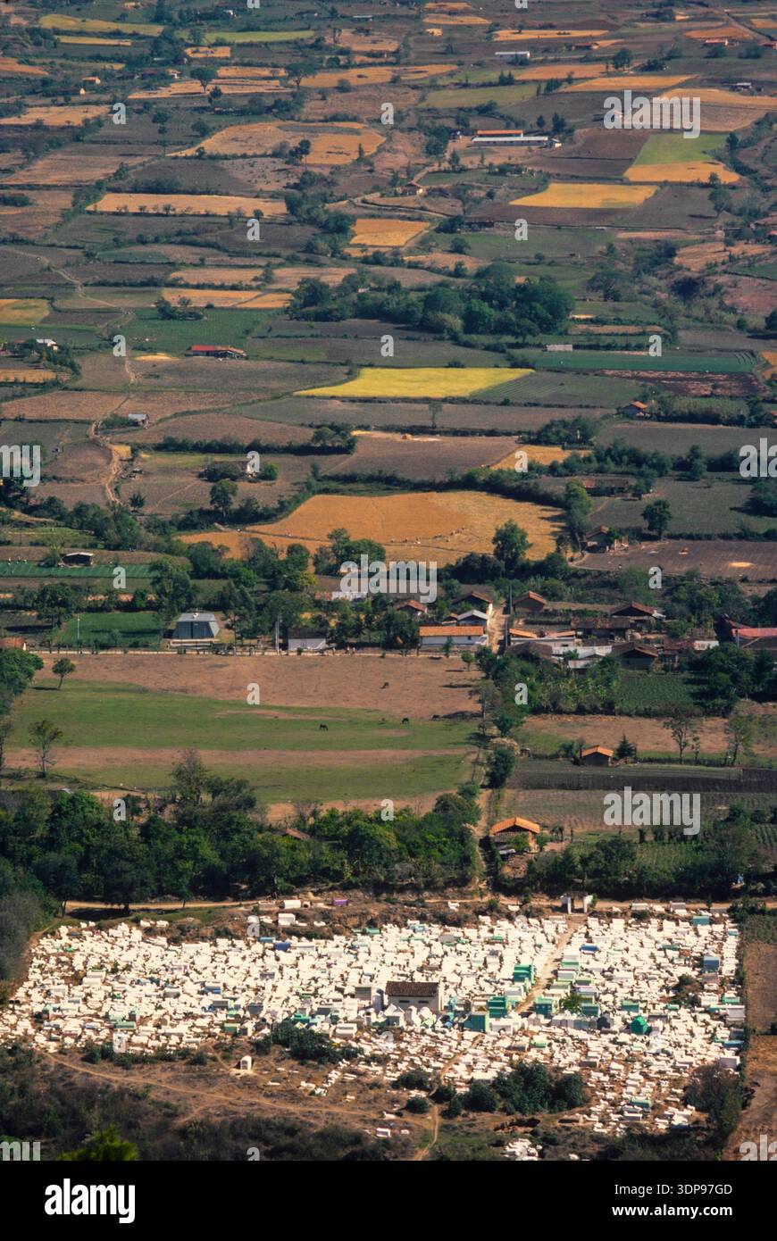 Un paesaggio rurale con il cimitero del villaggio in primo piano, Guatemala, marzo 1986 Foto Stock