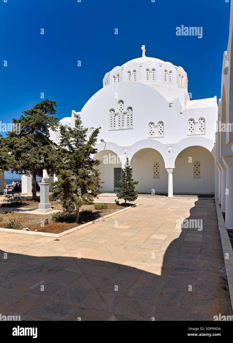 La cattedrale metropolitana di Ypapanti, Fira, Santorini, Grecia, una suggestiva chiesa bianca con cupola e croce, accoglie i visitatori sotto un blu brillante Foto Stock