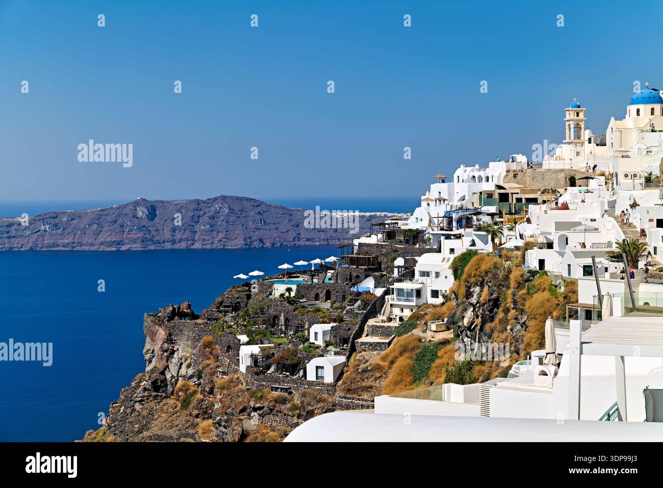 Santorini, Grecia: Villaggio sulla scogliera imbiancato con chiese dalla cupola blu che si affacciano sul Mar Egeo e isole lontane, una destinazione turistica popolare Foto Stock
