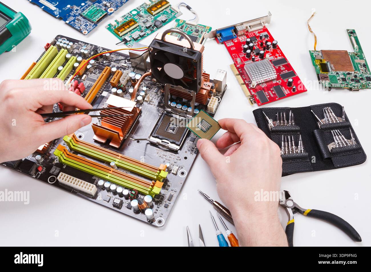 Il tecnico collega il microprocessore alla scheda madre Foto Stock