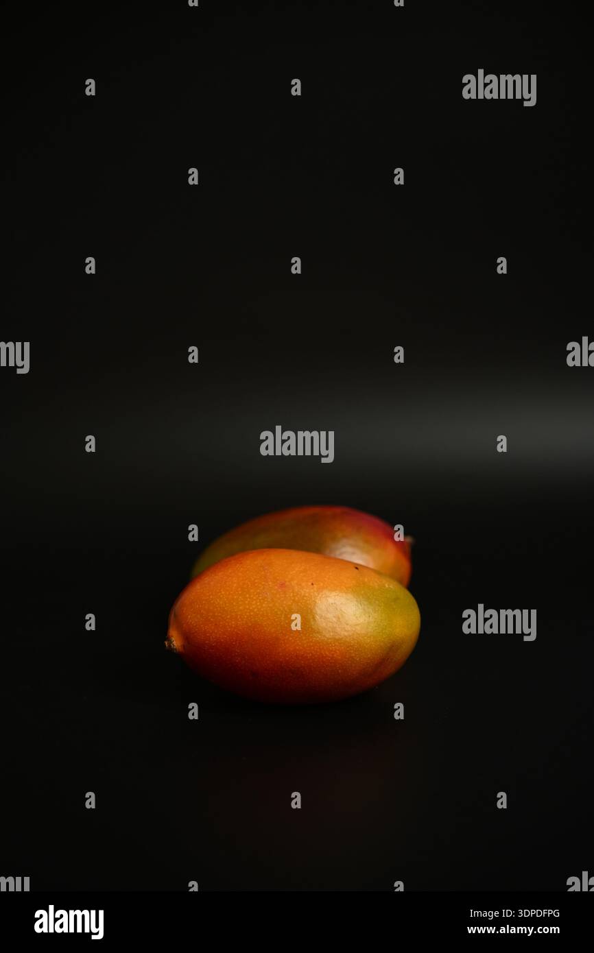 Minima natura morta del mango su sfondo nero per una dieta sana e temi nutrizionali Foto Stock