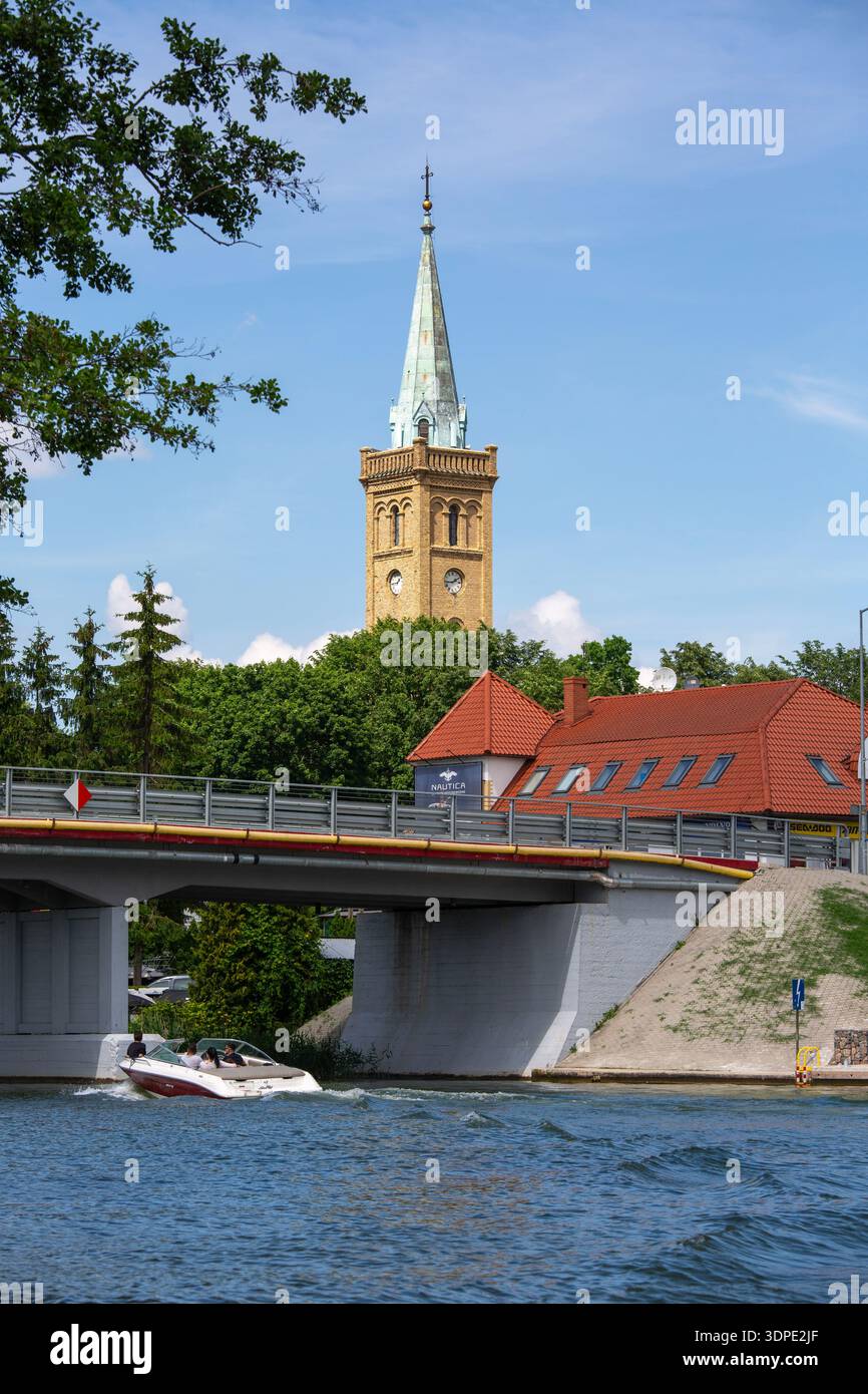 Mikolajki, Masurian Lake Land, Masuria, Polonia - 24 giugno 2020: Veduta del ponte sul lago Talty e della torre della chiesa della Santissima Trinità Foto Stock
