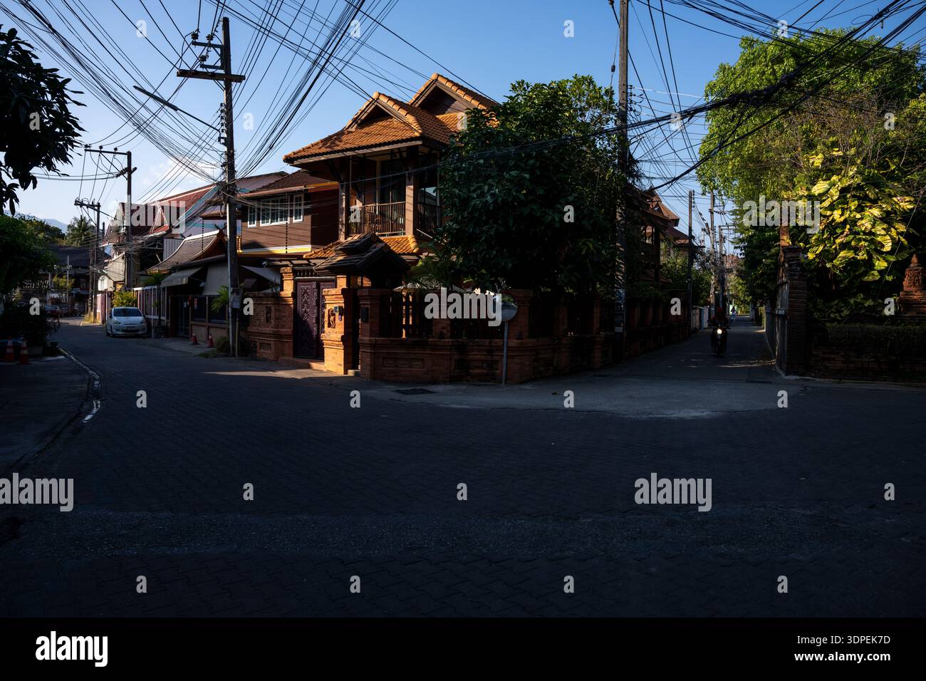 Il sole di mattina presto illumina una tradizionale casa in legno in stile Lanna in un angolo di strada tranquillo nella città vecchia di Chiang mai, in Thailandia. Lo scen atmosferico Foto Stock