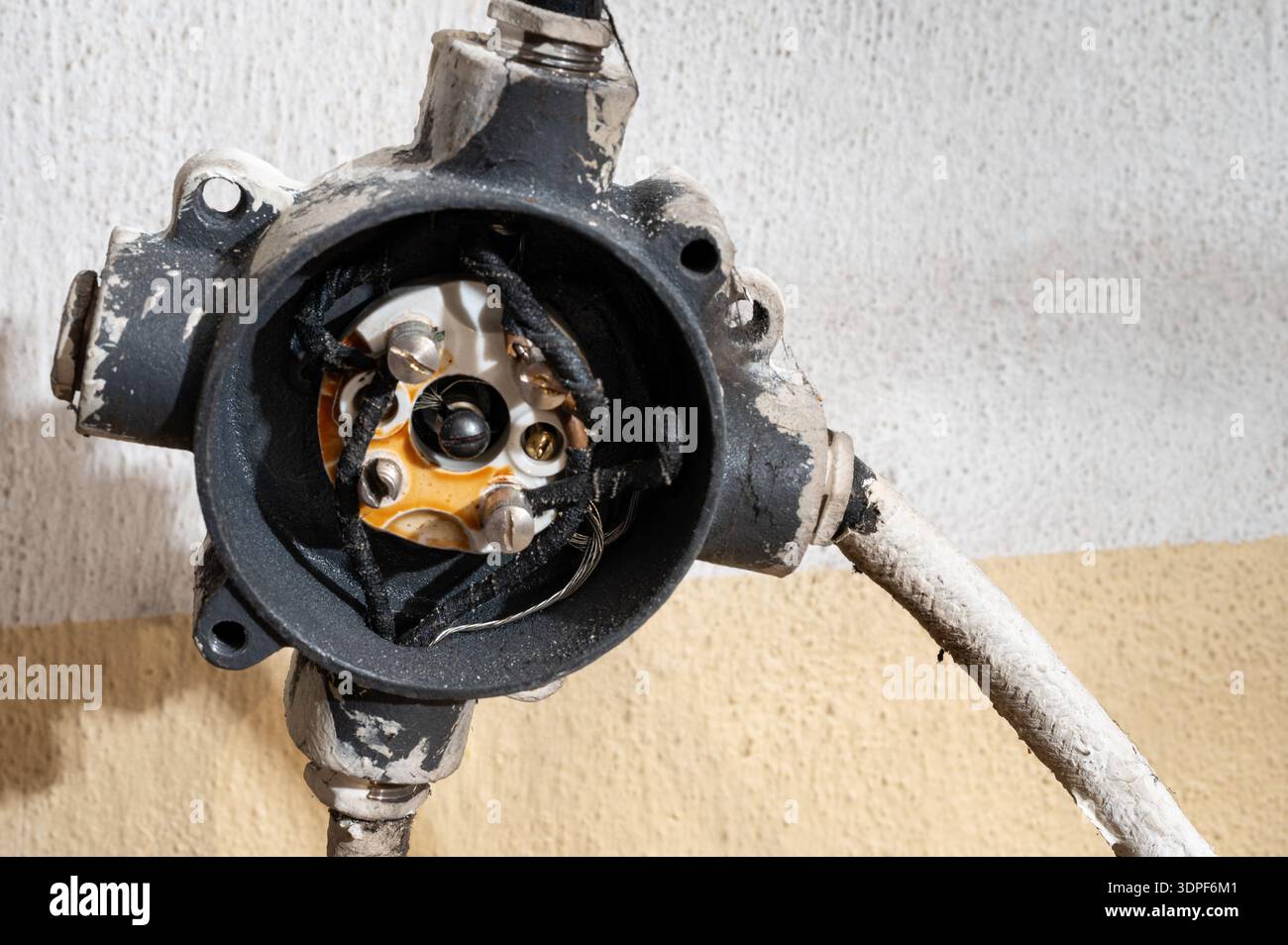 Primo piano di una scatola di derivazione elettrica aperta con fili in rame esposti, che mostra i dettagli del cablaggio industriale, l'impianto elettrico e l'infrastruttura m. Foto Stock