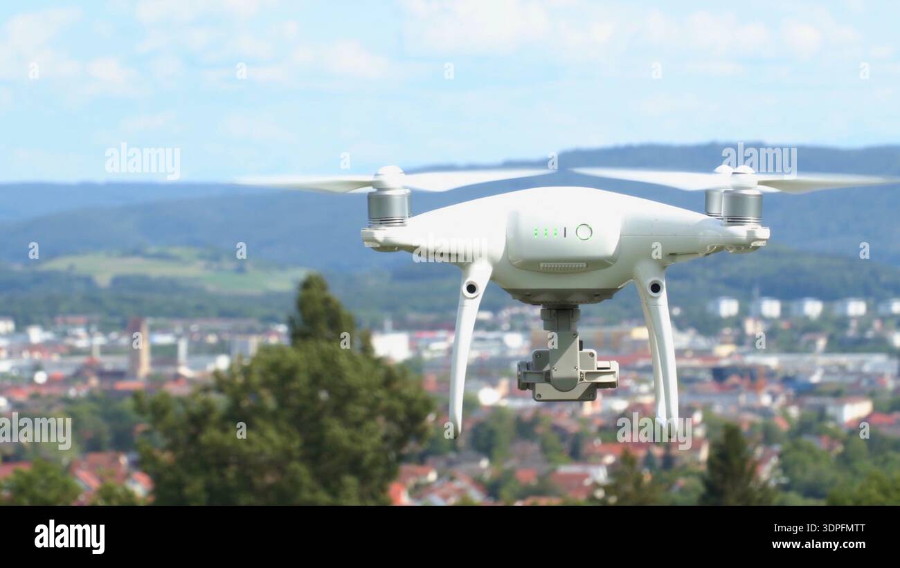 Il drone vola su una città con montagne sullo sfondo in una giornata limpida Foto Stock