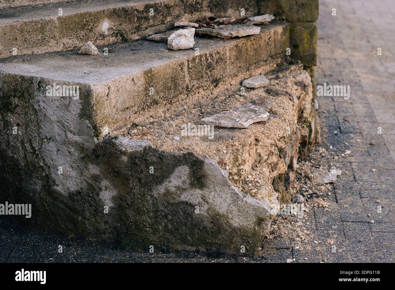 Vecchia scala Crumble. Passi antichi che mostrano decadimento e muschio nella tranquilla scena del cortile Foto Stock