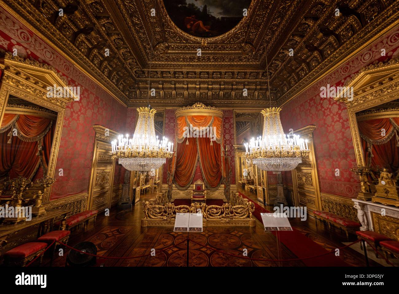 Torino, Italia - 10 agosto 2025: Sfarzosa sala del trono barocco nel Palazzo reale di Torino, con legno dorato, lampadari di cristallo, damasca rossa e caffè Foto Stock