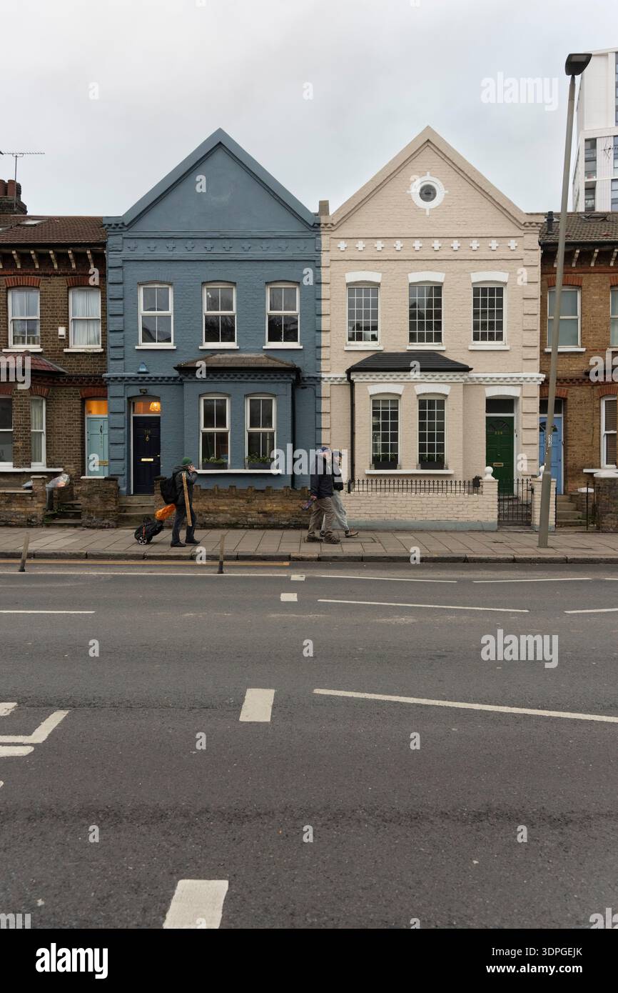 La gente passa davanti alle case vittoriane su Queenstown Road, Battersea London. Foto Stock