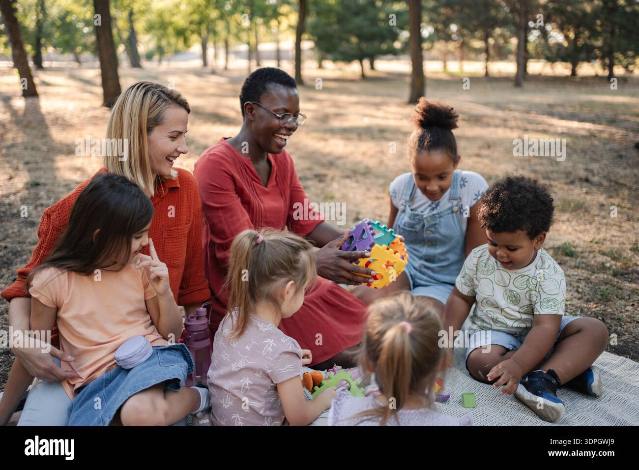Bambini e insegnanti si divertono insieme all'aperto Foto Stock