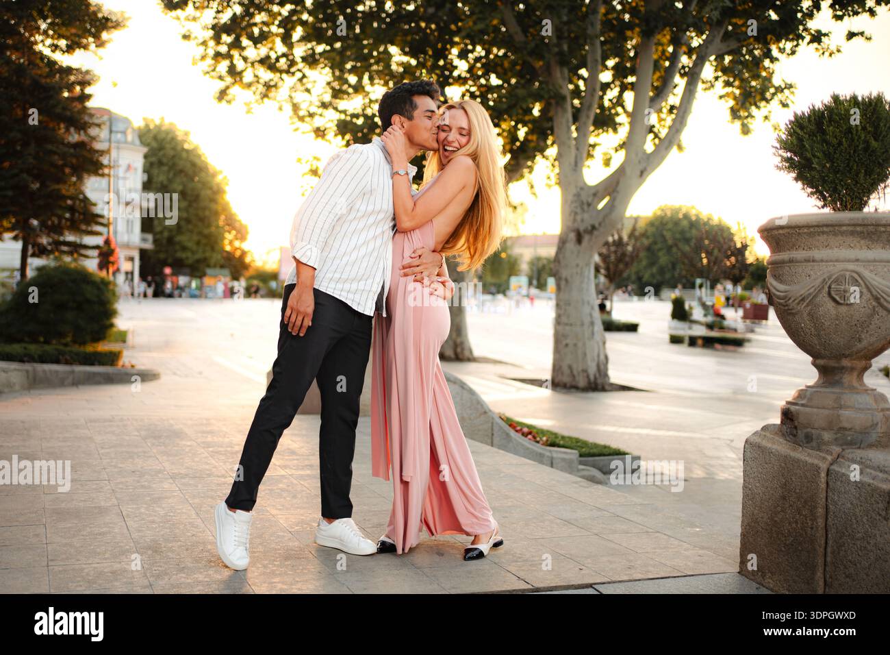 La coppia condivide un momento romantico nella luce dorata del crepuscolo Foto Stock