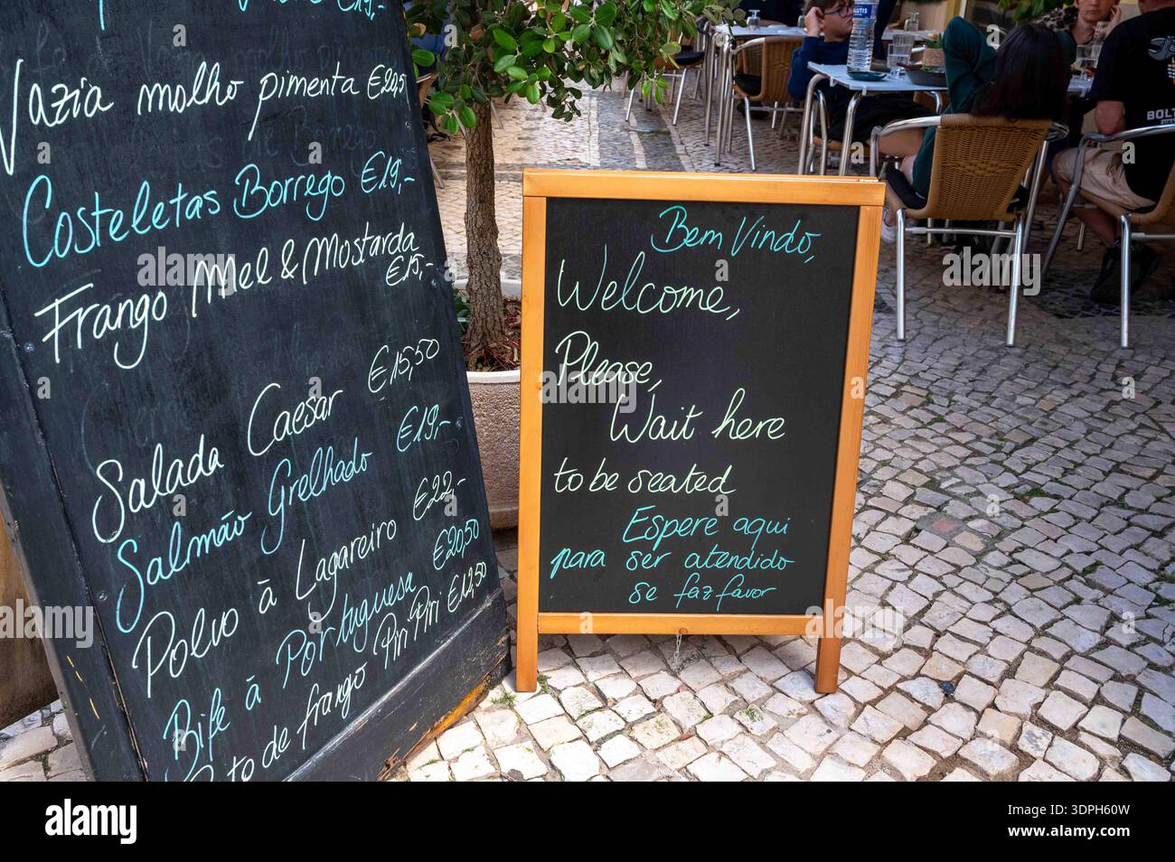 Ristorante all'aperto con menu scritto a mano, insegna Algarve Silves Portugal con ciottoli Foto Stock