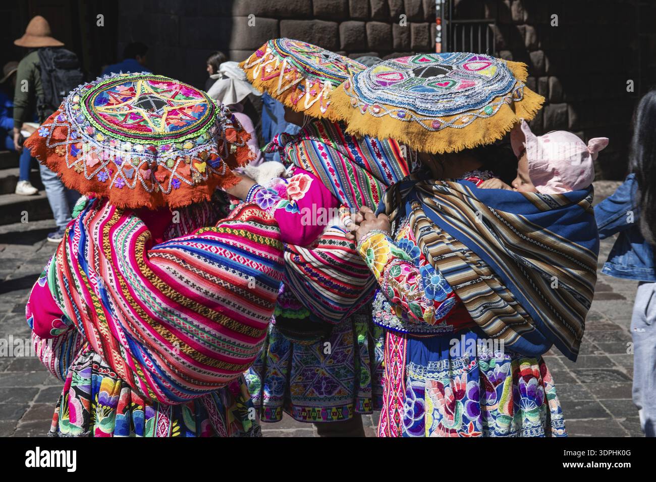 Donna indigena in costume tradizionale con agnelli che si fingono per scattare foto, Cusco, Perù Foto Stock