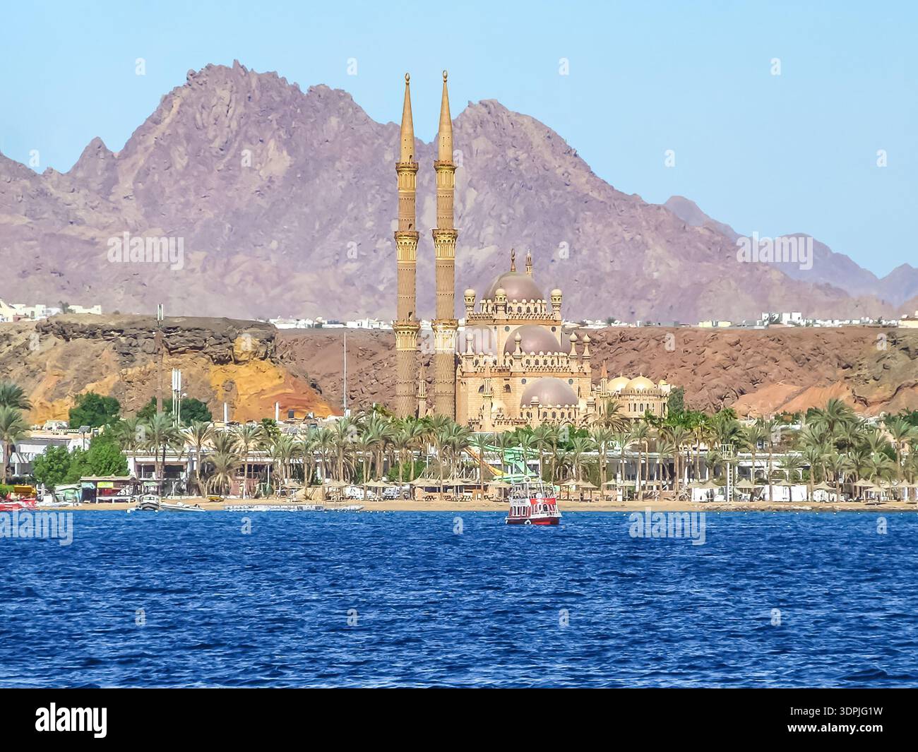 La barca galleggia sullo sfondo del Vecchio mercato e della Moschea al Sahaba a Sharm El Sheikh - vista dal Mar Rosso. Panorama incredibile Foto Stock