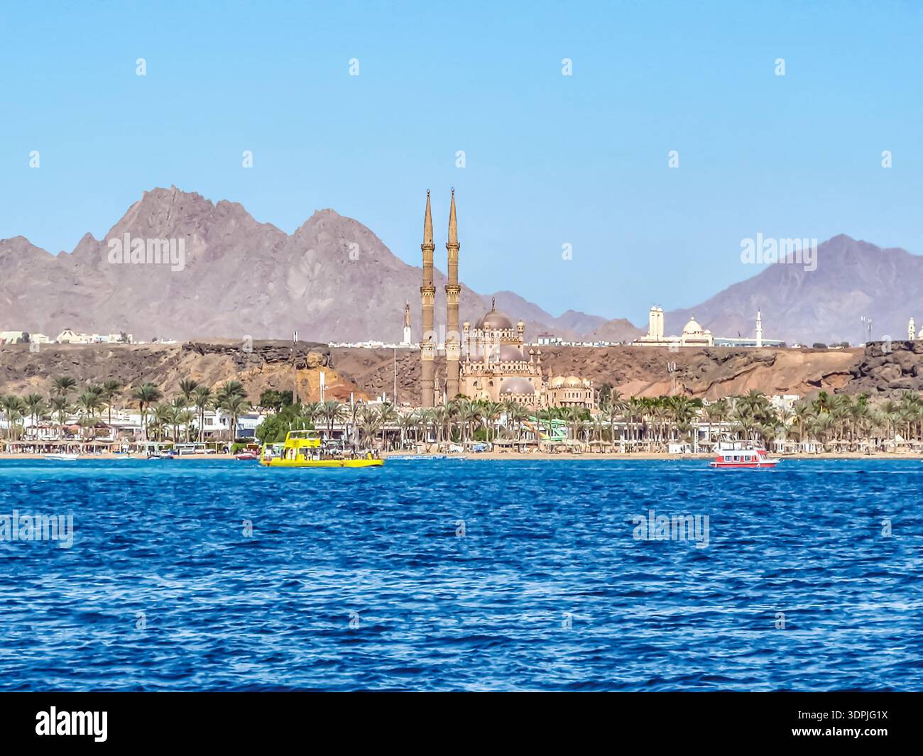 Le navi turistiche navigano nel Mar Rosso sullo sfondo della città Vecchia e della Moschea al Sahaba a Sharm El Sheikh, Egitto. Panorama delizioso Foto Stock