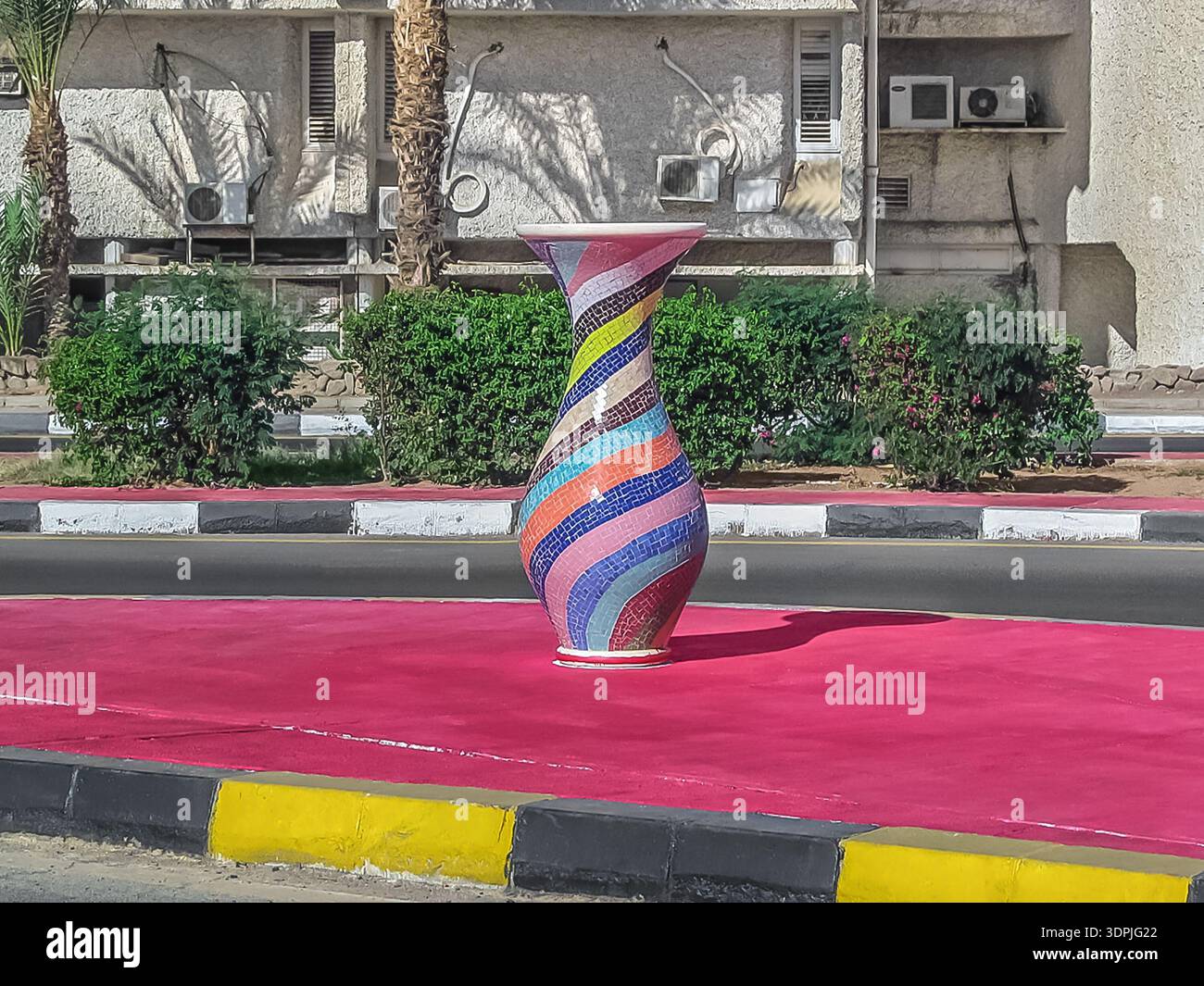 La colorata scultura in vaso a mosaico si trova nel mezzo della strada a Sharm EL Sheikh, Egitto. Una caraffa grande si trova sul marciapiede vicino alla strada all'aperto Foto Stock