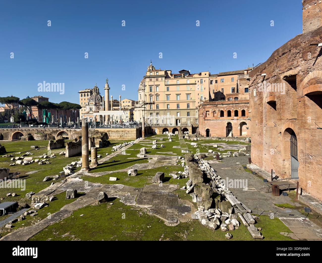 Antiche rovine del mercato di Traiano e dei fori Imperiali sotto un cielo azzurro a Roma, Italia. Una splendida vista sulla storia e l'architettura romane. Foto Stock