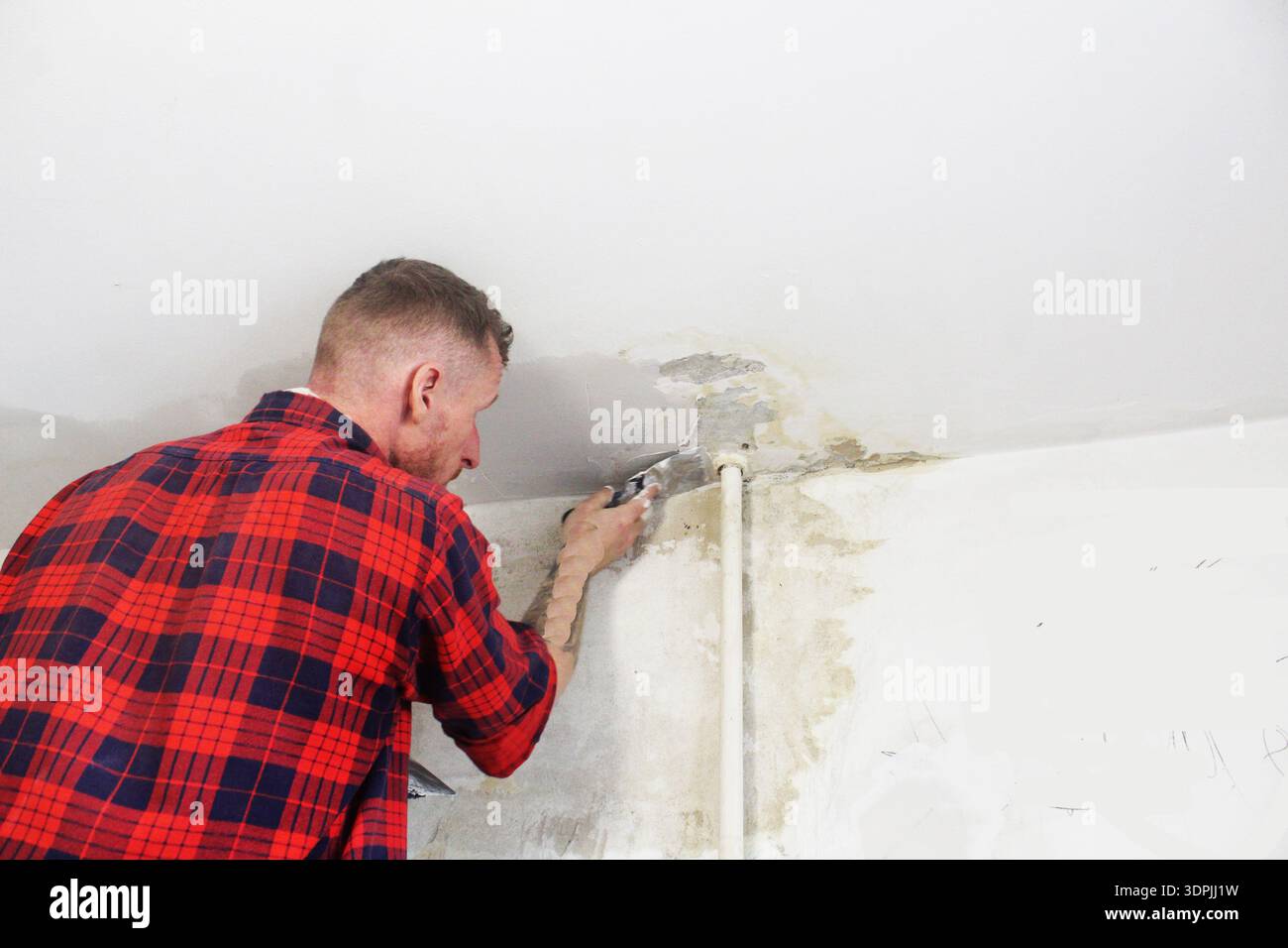 Il maestro infiltra le pareti e il soffitto con una spatola. Foto Stock