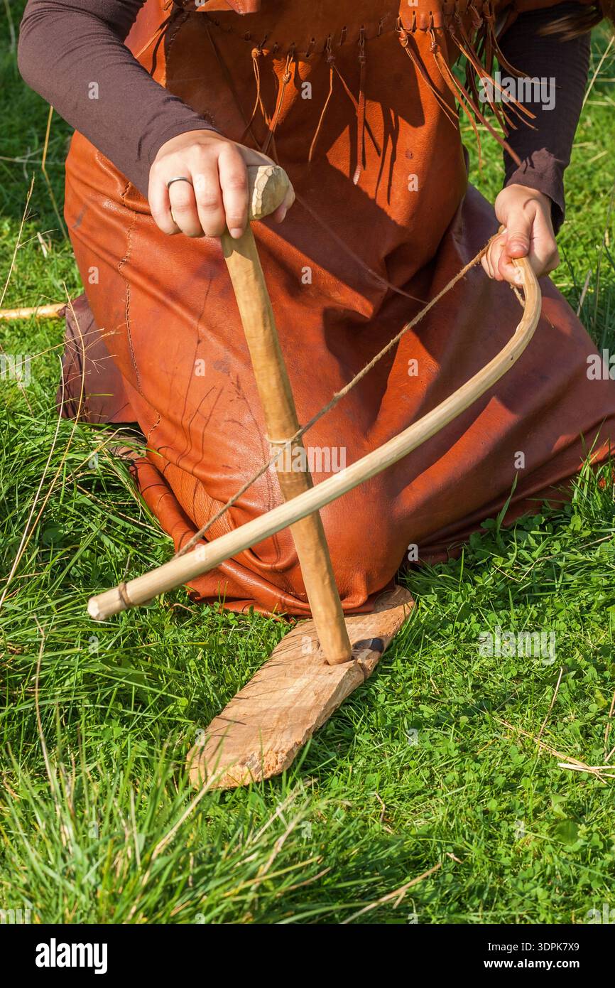 Donne che cercano di fare fuoco con un trapano ad arco Foto Stock