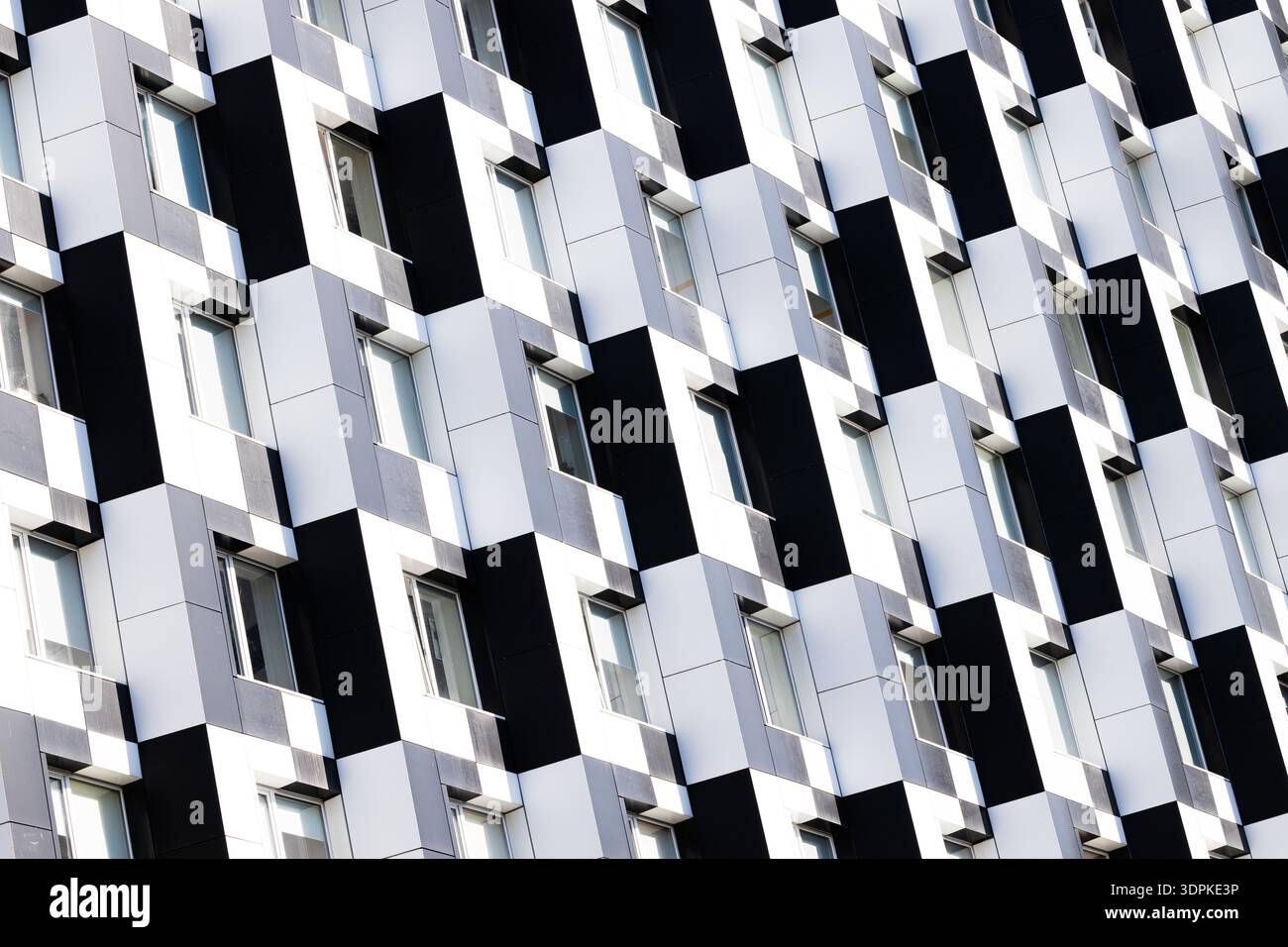 L'esterno di un edificio contemporaneo presenta un audace e ripetitivo schema di pannelli neri e bianchi alternati con finestre incassate Foto Stock