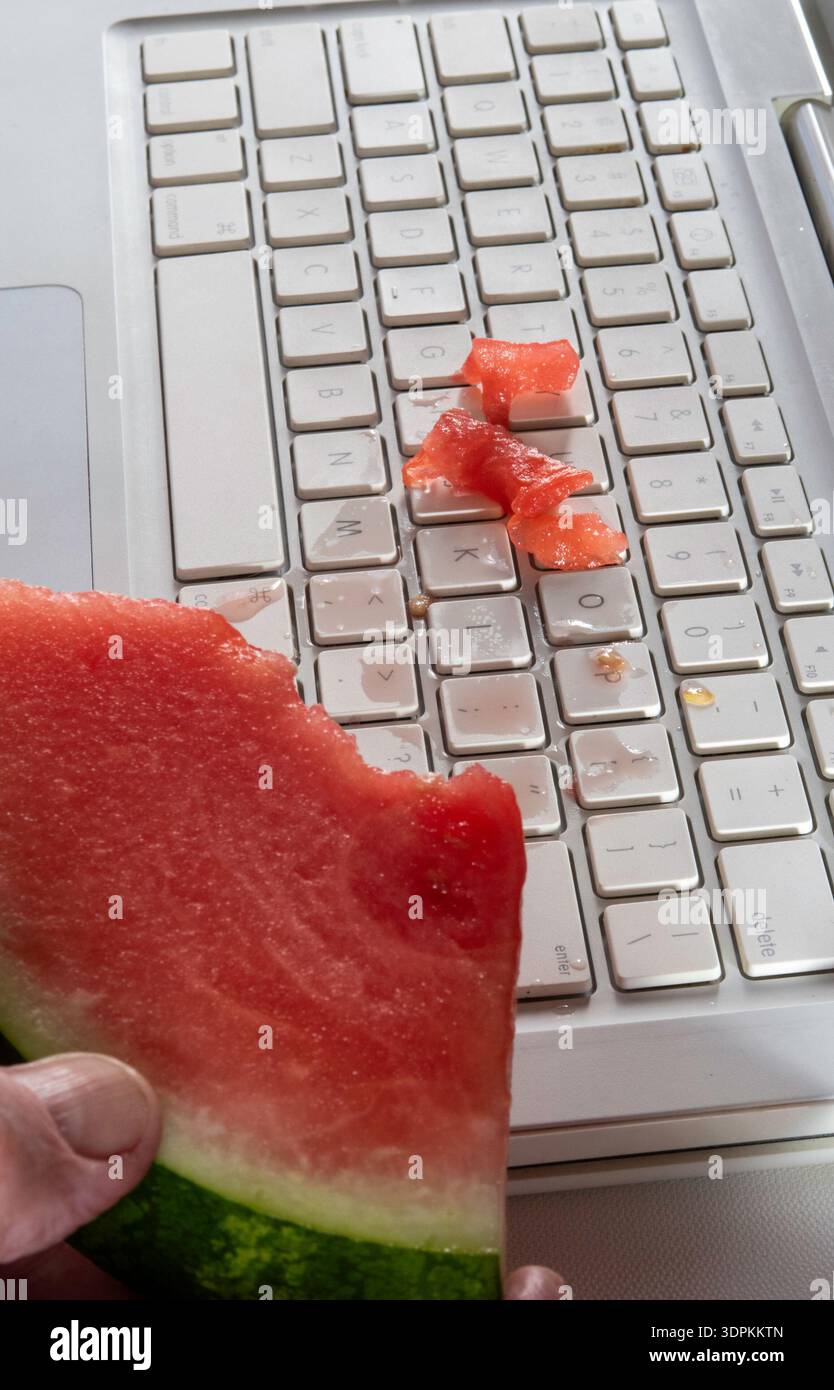 Primo piano dell'anguria versata sulla tastiera di un computer, 2026, Stati Uniti Foto Stock