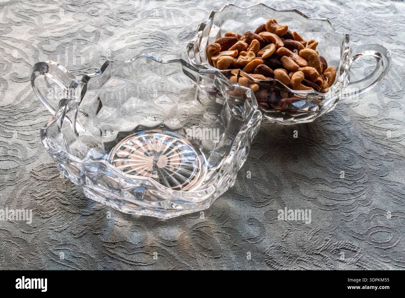 Natura morta degli anacardi in una delle due antiche ciotole Fostoria con manico di pannolini, Stati Uniti Foto Stock