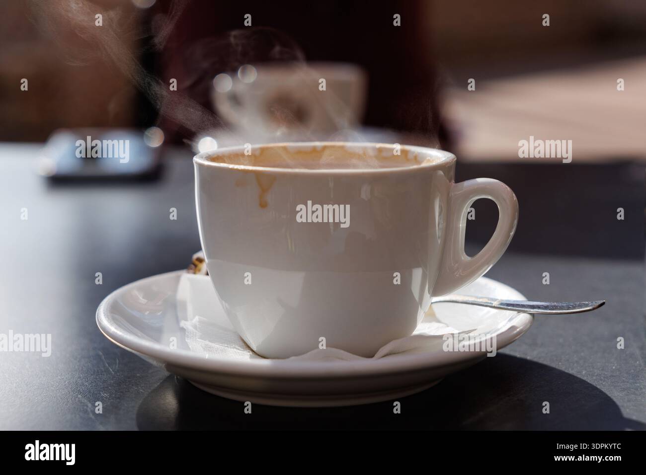 Montare il caffè a vapore con il latte retroilluminato su un tavolo da bar all'aperto, Spagna Foto Stock