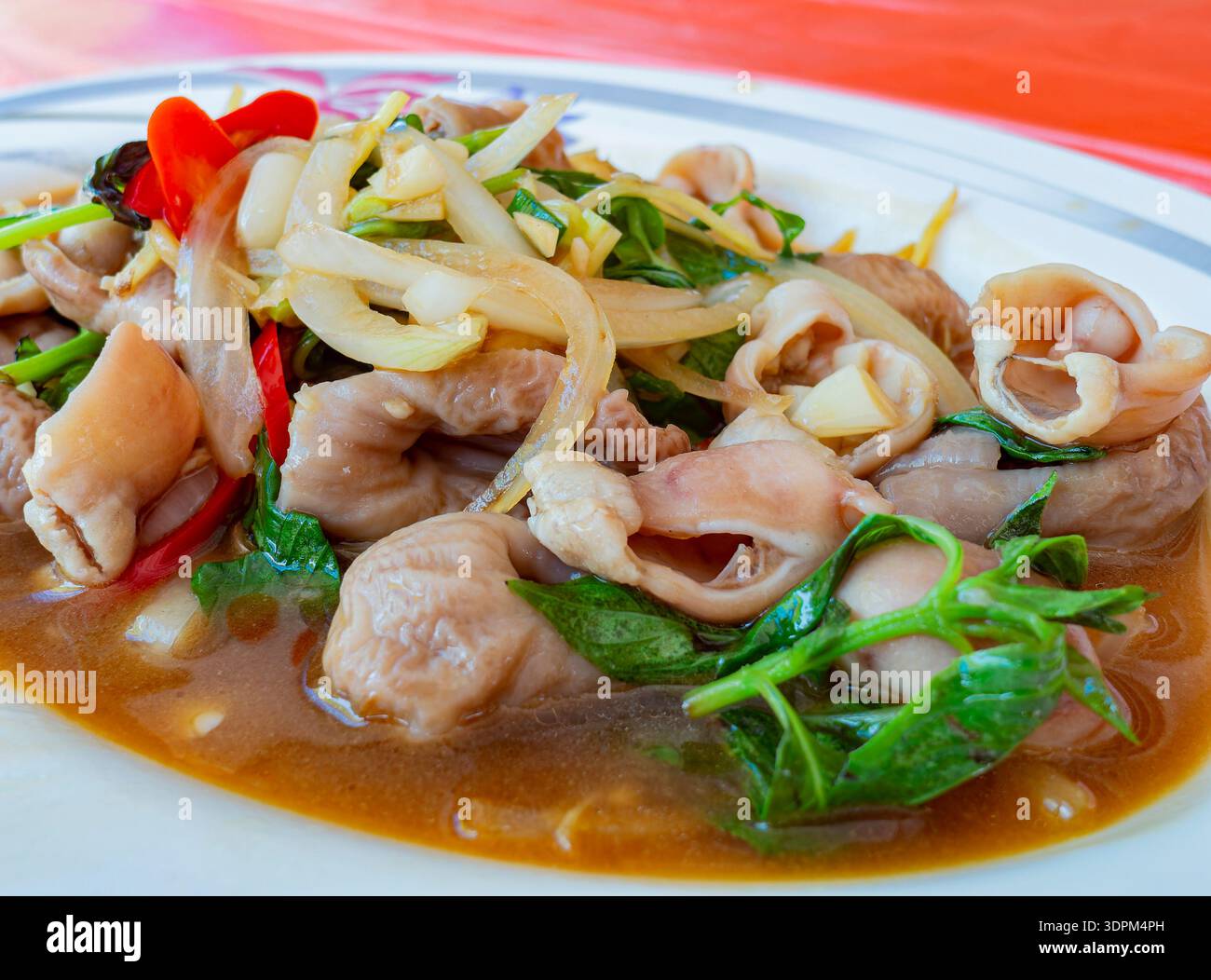 intestini di maiale croccanti saltati in padella con basilico fresco Foto Stock