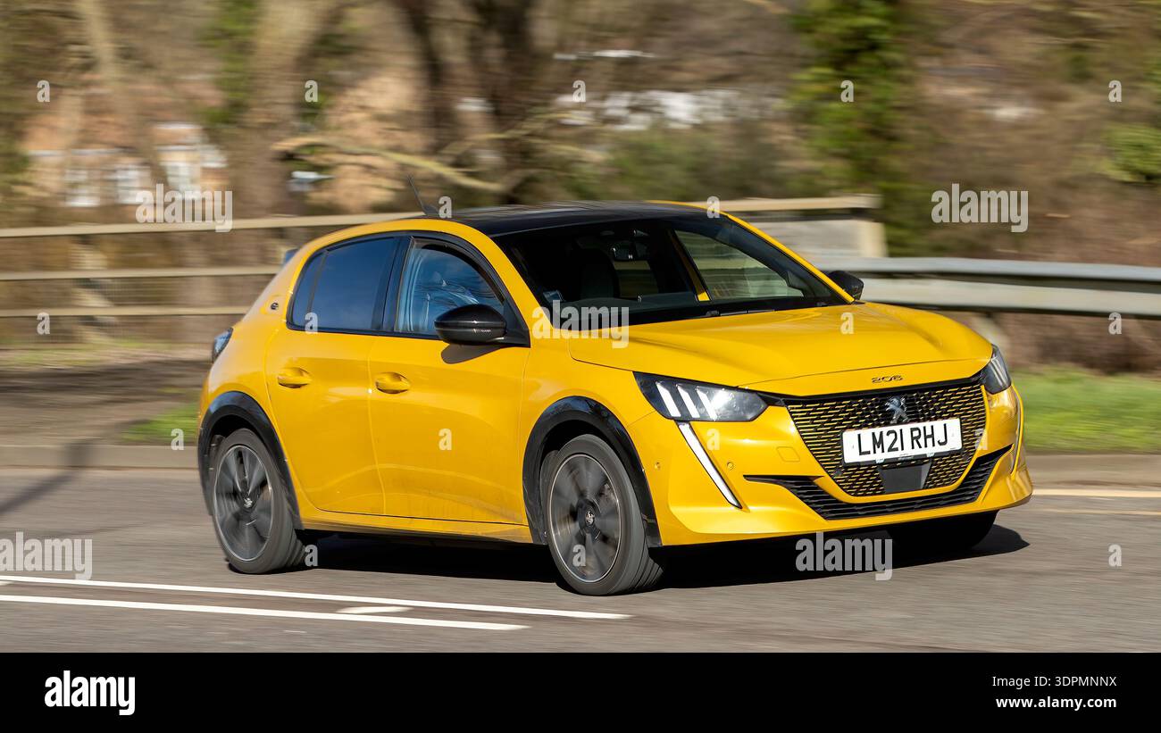 Milton Keynes,Bucks,UK - 14 febbraio 2026: 2021 Peugeot giallo 208 GT auto elettrica gialla che guida su una strada britannica Foto Stock